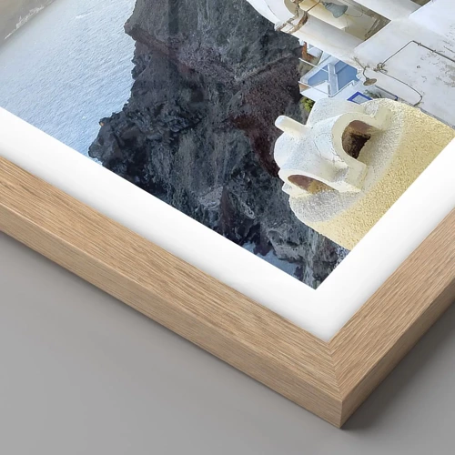 Een poster in een licht eiken lijst - Santorini - genesteld tegen de rotsen - 91x61 cm