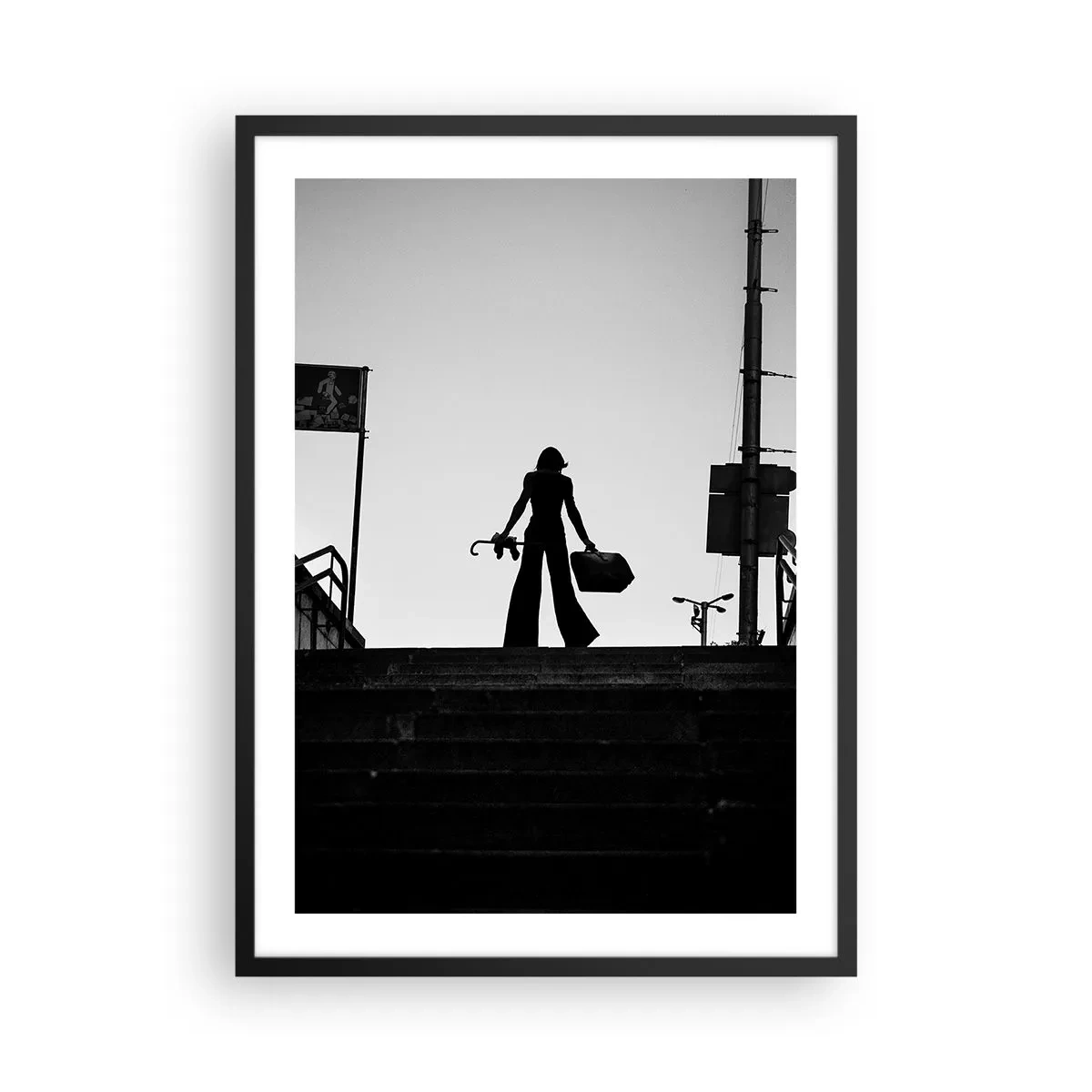 Poster in een zwarte lijst - Silhouet van een vrouw met een koffer tegen de achtergrond van de ondergaande zon - 50x70cm - Stedelijk dwalen - Moderne wanddecoratie voor woonkamer en slaapkamer ARTTOR