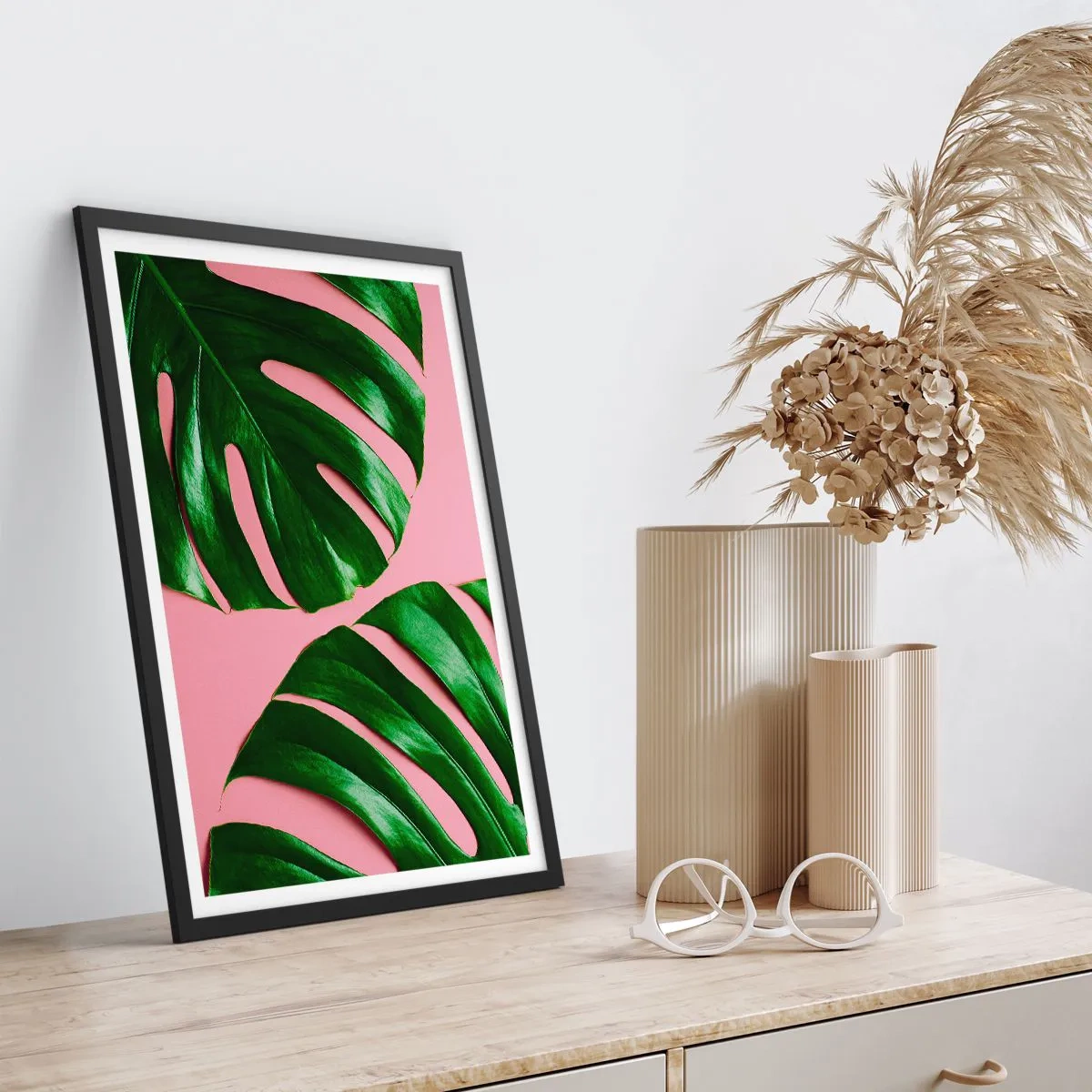 Poster in een zwarte lijst - Monsterabladeren op een roze achtergrond in minimalistische stijl - 50x70cm - Groene rendez-vous - Moderne wanddecoratie voor woonkamer en slaapkamer ARTTOR