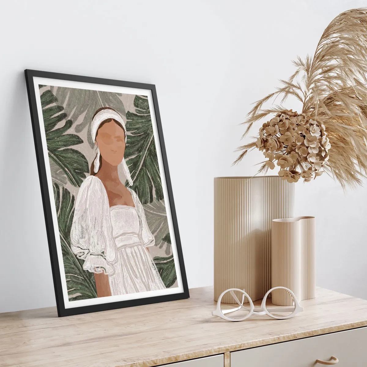 Poster in een zwarte lijst - Een vrouw in een witte jurk tegen een achtergrond van groene bladeren - 50x70cm - Exotisch portret - Moderne wanddecoratie voor woonkamer en slaapkamer ARTTOR