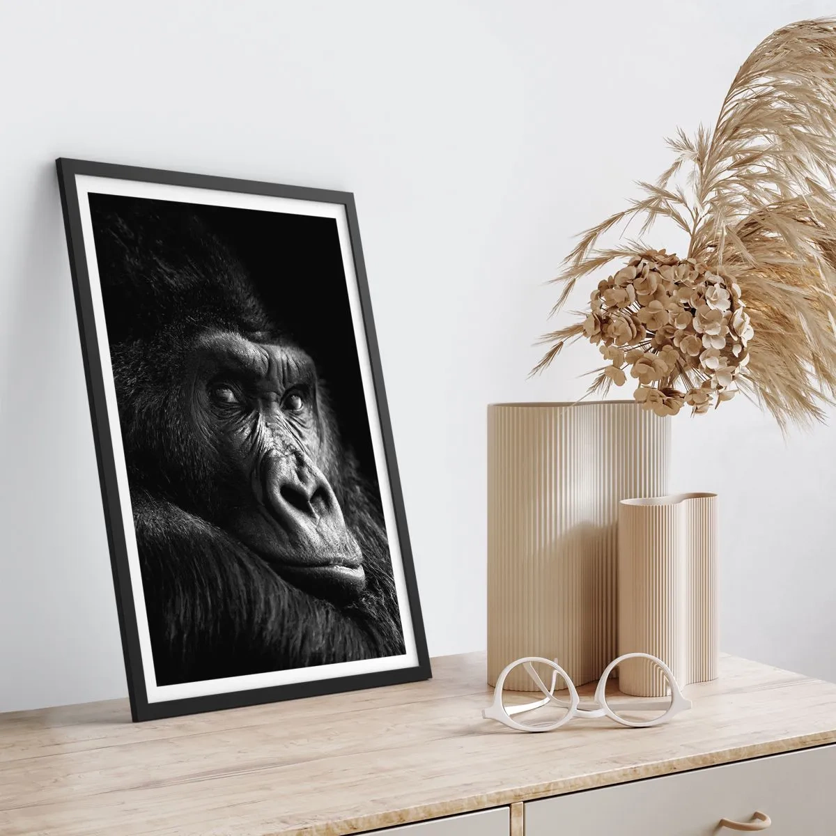 Poster in een zwarte lijst - Portret van een gorilla tegen een zwarte achtergrond in levendige details - 50x70cm - En waar kijk je naar? - Moderne wanddecoratie voor woonkamer en slaapkamer ARTTOR
