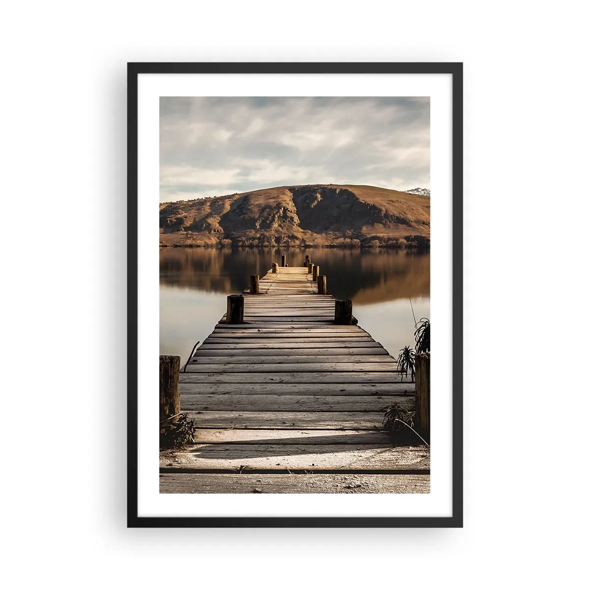 Poster in een zwarte lijst - Een houten steiger leidt naar een rustig meer met een bergachtige achtergrond - 50x70cm - Landschap in stilte - Moderne wanddecoratie voor woonkamer en slaapkamer ARTTOR